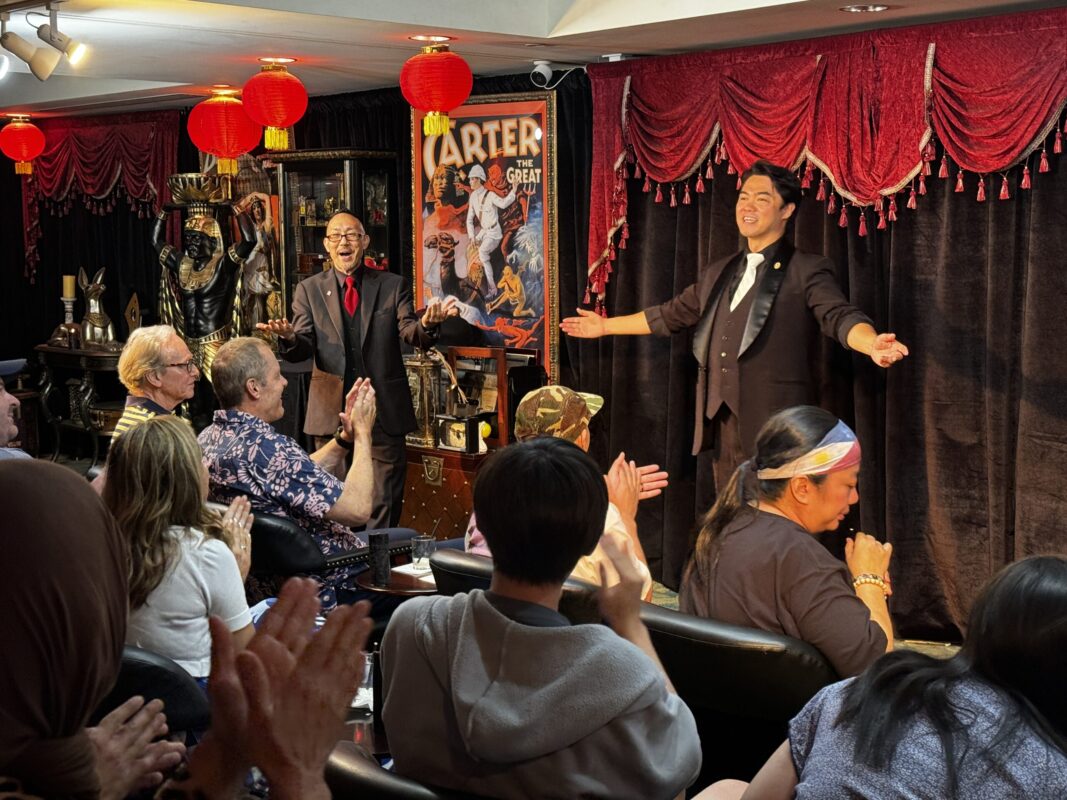 Man performing a magic show on stage in front of an audience