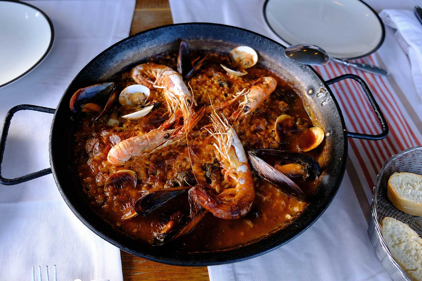 A clay pot filled with Arroz de Marisco, a rich and soupy Portuguese seafood rice stew.