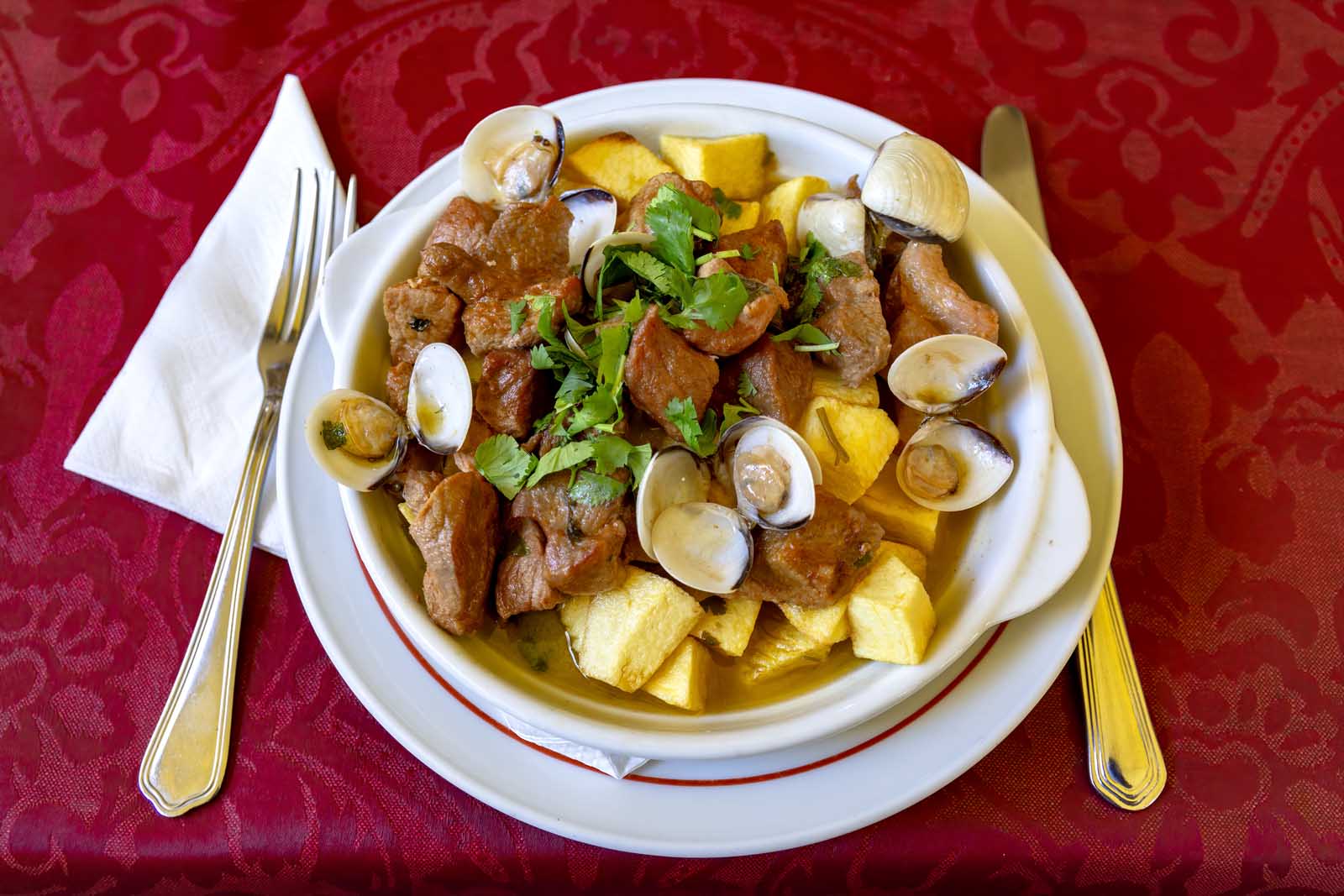 A traditional Portuguese dish of Carne de Porco à Alentejana, featuring marinated pork and fresh clams.