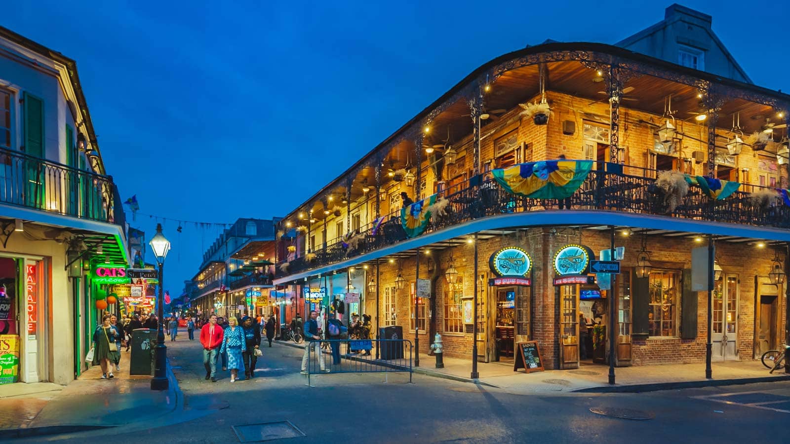A historic wrought-iron balcony in the French Quarter of New Orleans, decorated with festive Christmas garlands.