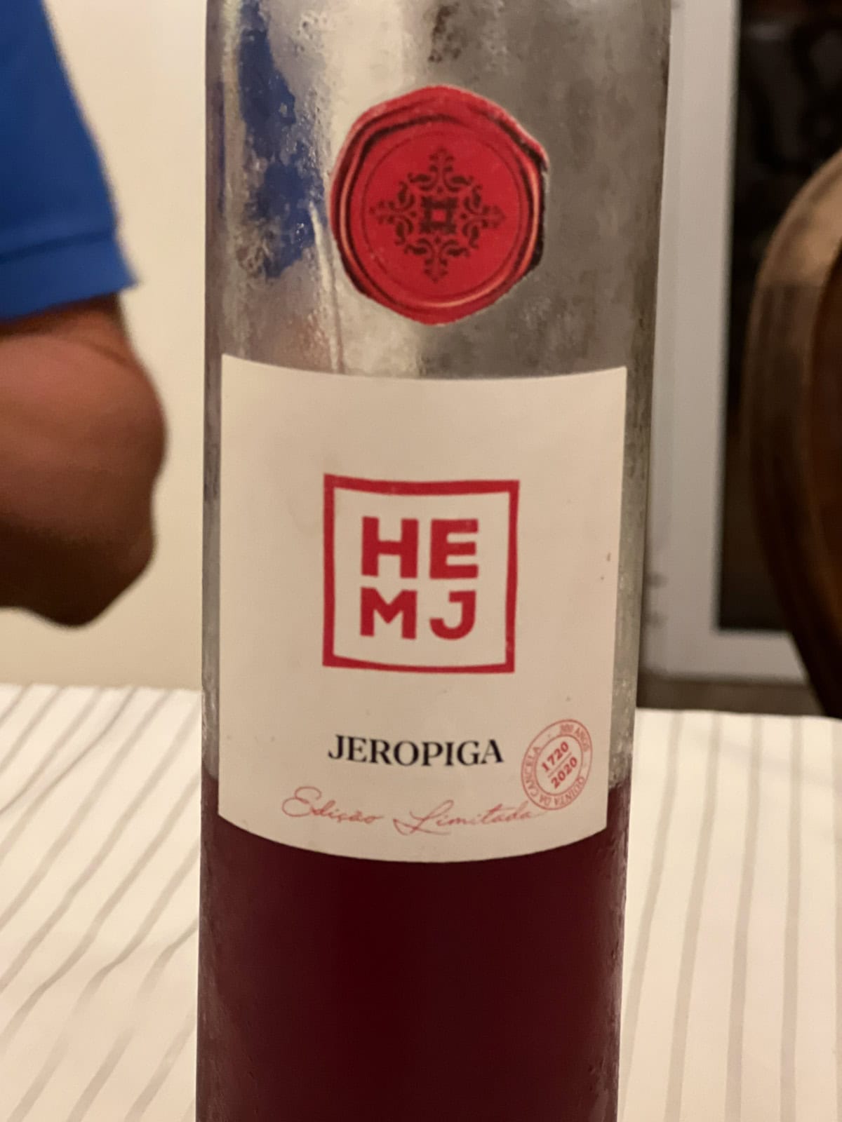 A bottlet of Ginjinha, a traditional Portuguese sour cherry liqueur, that is usually being served in a chocolate cup.