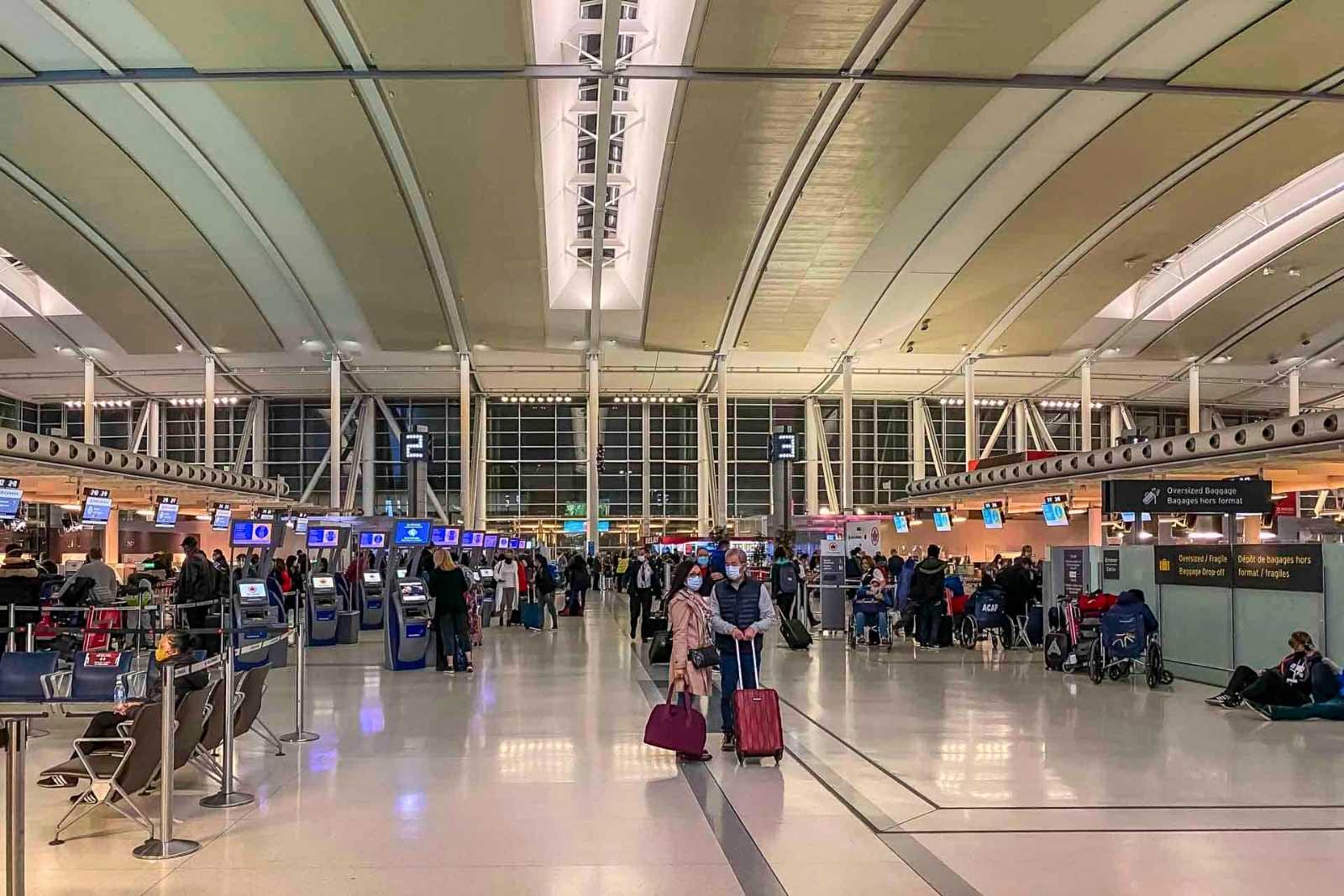 Toronto Pearson airport check-in area with travelers and luggage, showing how checked bags enter airport baggage systems.